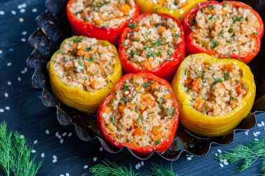 Doldurulmuş biber. Biberli pilav ve kıyma. Siyah arka planda, dökme demir bir tavada pişmiş biber. Sağlıklı Romanya yemekleri.
