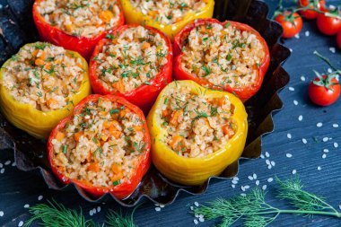 Doldurulmuş biber. Biberli pilav ve kıyma. Siyah arka planda, dökme demir bir tavada pişmiş biber. Sağlıklı Romanya yemekleri.