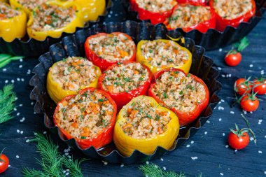 Doldurulmuş biber. Biberli pilav ve kıyma. Siyah arka planda, dökme demir bir tavada pişmiş biber. Sağlıklı Romanya yemekleri.