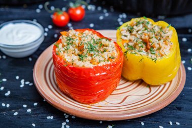 Doldurulmuş biber. Biberli pilav ve kıyma. Siyah arka planda, dökme demir bir tavada pişmiş biber. Sağlıklı Romanya yemekleri.