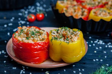 Doldurulmuş biber. Biberli pilav ve kıyma. Siyah arka planda, dökme demir bir tavada pişmiş biber. Sağlıklı Romanya yemekleri.