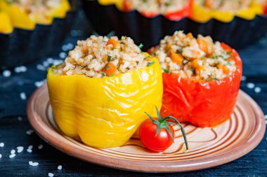 Doldurulmuş biber. Biberli pilav ve kıyma. Siyah arka planda, dökme demir bir tavada pişmiş biber. Sağlıklı Romanya yemekleri.