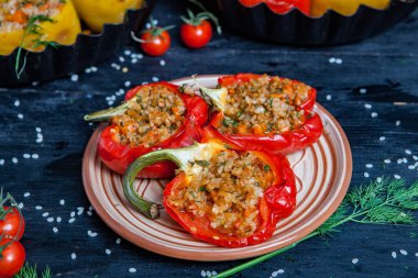 Doldurulmuş biber. Biberli pilav ve kıyma. Siyah arka planda, dökme demir bir tavada pişmiş biber. Sağlıklı Romanya yemekleri.