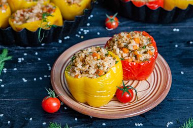 Doldurulmuş biber. Biberli pilav ve kıyma. Siyah arka planda, dökme demir bir tavada pişmiş biber. Sağlıklı Romanya yemekleri.