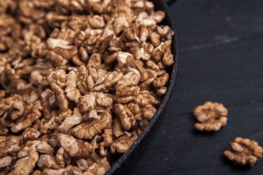 Ceviz arkaplan. Siyah bir tabakta soyulan cevizler. ceviz vitamin ve sebze yağlarıyla dolu gerçek bir süper yemek.