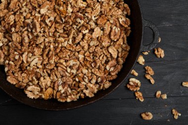 Ceviz arkaplan. Siyah bir tabakta soyulan cevizler. ceviz vitamin ve sebze yağlarıyla dolu gerçek bir süper yemek.