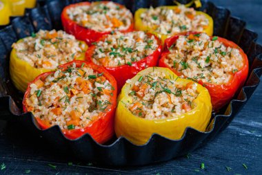 Doldurulmuş biber. Biberli pilav ve kıyma. Siyah arka planda, dökme demir bir tavada pişmiş biber. Sağlıklı Romanya yemekleri.