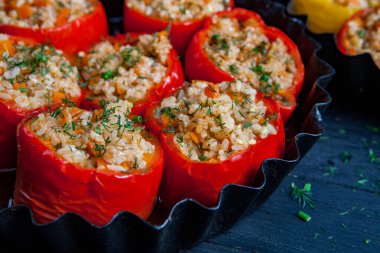 Doldurulmuş biber. Biberli pilav ve kıyma. Siyah arka planda, dökme demir bir tavada pişmiş biber. Sağlıklı Romanya yemekleri.