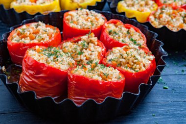 Doldurulmuş biber. Biberli pilav ve kıyma. Siyah arka planda, dökme demir bir tavada pişmiş biber. Sağlıklı Romanya yemekleri.