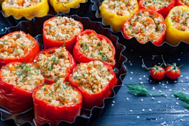 Doldurulmuş biber. Biberli pilav ve kıyma. Siyah arka planda, dökme demir bir tavada pişmiş biber. Sağlıklı Romanya yemekleri.