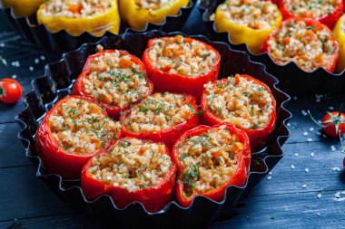 Doldurulmuş biber. Biberli pilav ve kıyma. Siyah arka planda, dökme demir bir tavada pişmiş biber. Sağlıklı Romanya yemekleri.
