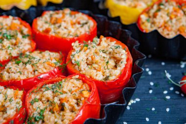 Doldurulmuş biber. Biberli pilav ve kıyma. Siyah arka planda, dökme demir bir tavada pişmiş biber. Sağlıklı Romanya yemekleri.