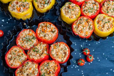 Doldurulmuş biber. Biberli pilav ve kıyma. Siyah arka planda, dökme demir bir tavada pişmiş biber. Sağlıklı Romanya yemekleri.