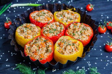 Doldurulmuş biber. Biberli pilav ve kıyma. Siyah arka planda, dökme demir bir tavada pişmiş biber. Sağlıklı Romanya yemekleri.