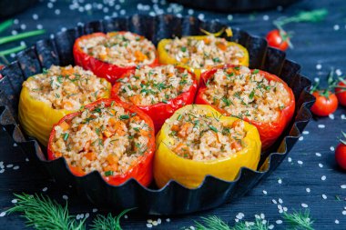 Doldurulmuş biber. Biberli pilav ve kıyma. Siyah arka planda, dökme demir bir tavada pişmiş biber. Sağlıklı Romanya yemekleri.