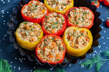 Doldurulmuş biber. Biberli pilav ve kıyma. Siyah arka planda, dökme demir bir tavada pişmiş biber. Sağlıklı Romanya yemekleri.