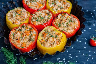 Doldurulmuş biber. Biberli pilav ve kıyma. Siyah arka planda, dökme demir bir tavada pişmiş biber. Sağlıklı Romanya yemekleri.