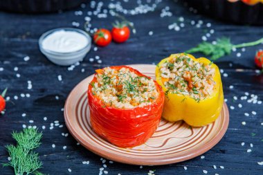 Doldurulmuş biber. Biberli pilav ve kıyma. Siyah arka planda, dökme demir bir tavada pişmiş biber. Sağlıklı Romanya yemekleri.