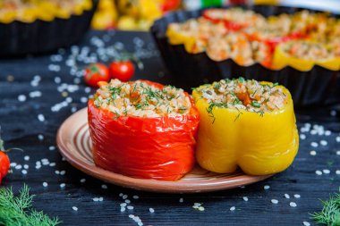 Doldurulmuş biber. Biberli pilav ve kıyma. Siyah arka planda, dökme demir bir tavada pişmiş biber. Sağlıklı Romanya yemekleri.