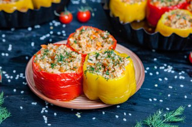 Doldurulmuş biber. Biberli pilav ve kıyma. Siyah arka planda, dökme demir bir tavada pişmiş biber. Sağlıklı Romanya yemekleri.