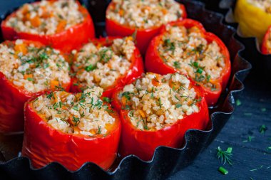 Doldurulmuş biber. Biberli pilav ve kıyma. Siyah arka planda, dökme demir bir tavada pişmiş biber. Sağlıklı Romanya yemekleri.