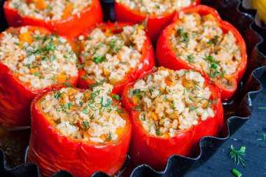 Doldurulmuş biber. Biberli pilav ve kıyma. Siyah arka planda, dökme demir bir tavada pişmiş biber. Sağlıklı Romanya yemekleri.
