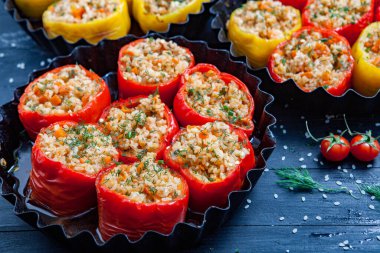 Doldurulmuş biber. Biberli pilav ve kıyma. Siyah arka planda, dökme demir bir tavada pişmiş biber. Sağlıklı Romanya yemekleri.