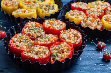 Doldurulmuş biber. Biberli pilav ve kıyma. Siyah arka planda, dökme demir bir tavada pişmiş biber. Sağlıklı Romanya yemekleri.