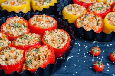 Doldurulmuş biber. Biberli pilav ve kıyma. Siyah arka planda, dökme demir bir tavada pişmiş biber. Sağlıklı Romanya yemekleri.