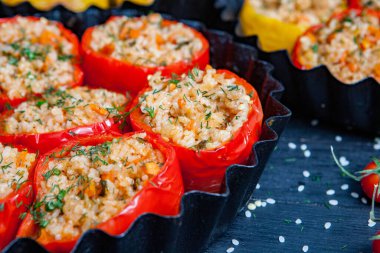 Doldurulmuş biber. Biberli pilav ve kıyma. Siyah arka planda, dökme demir bir tavada pişmiş biber. Sağlıklı Romanya yemekleri.