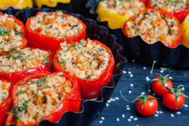 Doldurulmuş biber. Biberli pilav ve kıyma. Siyah arka planda, dökme demir bir tavada pişmiş biber. Sağlıklı Romanya yemekleri.
