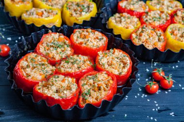 Doldurulmuş biber. Biberli pilav ve kıyma. Siyah arka planda, dökme demir bir tavada pişmiş biber. Sağlıklı Romanya yemekleri.