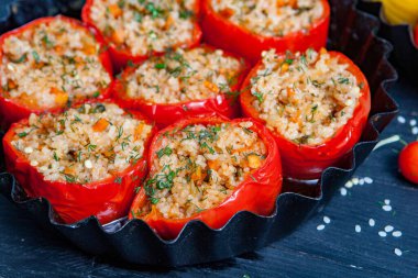 Doldurulmuş biber. Biberli pilav ve kıyma. Siyah arka planda, dökme demir bir tavada pişmiş biber. Sağlıklı Romanya yemekleri.