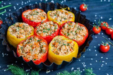 Doldurulmuş biber. Biberli pilav ve kıyma. Siyah arka planda, dökme demir bir tavada pişmiş biber. Sağlıklı Romanya yemekleri.
