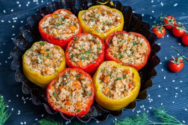 Doldurulmuş biber. Biberli pilav ve kıyma. Siyah arka planda, dökme demir bir tavada pişmiş biber. Sağlıklı Romanya yemekleri.