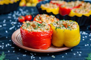 Doldurulmuş biber. Biberli pilav ve kıyma. Siyah arka planda, dökme demir bir tavada pişmiş biber. Sağlıklı Romanya yemekleri.