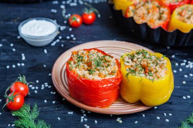 Doldurulmuş biber. Biberli pilav ve kıyma. Siyah arka planda, dökme demir bir tavada pişmiş biber. Sağlıklı Romanya yemekleri.