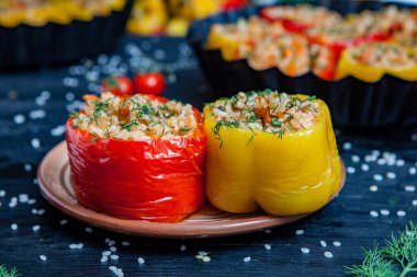 Doldurulmuş biber. Biberli pilav ve kıyma. Siyah arka planda, dökme demir bir tavada pişmiş biber. Sağlıklı Romanya yemekleri.