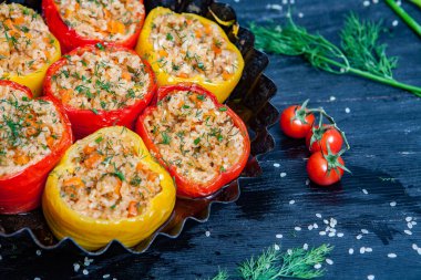 Doldurulmuş biber. Biberli pilav ve kıyma. Siyah arka planda, dökme demir bir tavada pişmiş biber. Sağlıklı Romanya yemekleri.