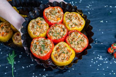 Doldurulmuş biber. Biberli pilav ve kıyma. Siyah arka planda, dökme demir bir tavada pişmiş biber. Sağlıklı Romanya yemekleri.