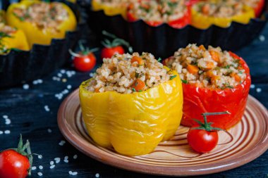 Doldurulmuş biber. Biberli pilav ve kıyma. Siyah arka planda, dökme demir bir tavada pişmiş biber. Sağlıklı Romanya yemekleri.