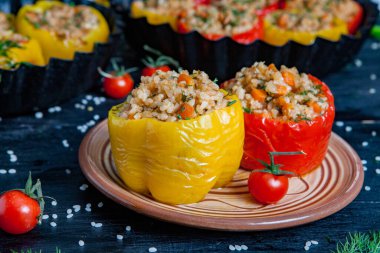 Doldurulmuş biber. Biberli pilav ve kıyma. Siyah arka planda, dökme demir bir tavada pişmiş biber. Sağlıklı Romanya yemekleri.