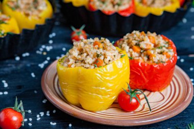 Doldurulmuş biber. Biberli pilav ve kıyma. Siyah arka planda, dökme demir bir tavada pişmiş biber. Sağlıklı Romanya yemekleri.