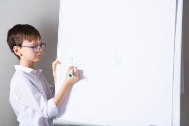 European white boy standing near school board for presentation. Education, childhood, homework and school concept.