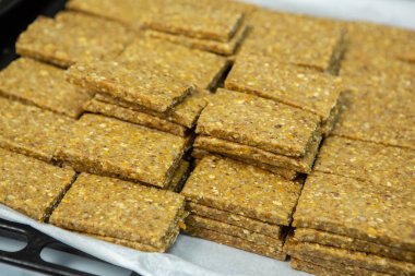 Fabrikadaki üretim hattını terk eden mısır gevreği veya protein çubukları. Meyve, fındık ve böğürtlenli sağlıklı egzersiz öncesi veya sonrası atıştırmalıklar. 