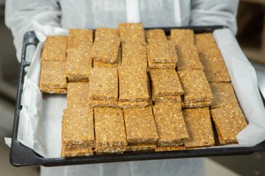 Fabrikadaki üretim hattını terk eden mısır gevreği veya protein çubukları. Meyve, fındık ve böğürtlenli sağlıklı egzersiz öncesi veya sonrası atıştırmalıklar. 