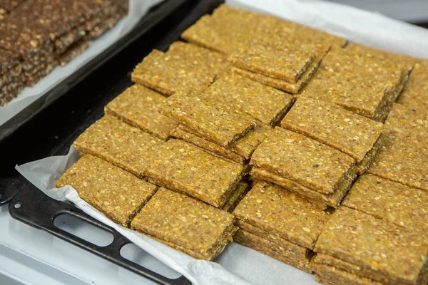 Assortment of cereal or protein bars that leave the assembly line at the factory. Healthy pre or post workout snacks with fruits, nuts and berries.