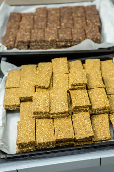 Assortment of cereal or protein bars that leave the assembly line at the factory. Healthy pre or post workout snacks with fruits, nuts and berries.