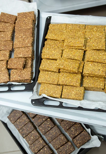 Assortment of cereal or protein bars that leave the assembly line at the factory. Healthy pre or post workout snacks with fruits, nuts and berries.