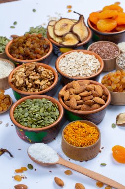 Sağlıklı vejetaryen gıda konsepti. Beyaz arka planda kurutulmuş meyve, fındık ve tohum çeşitleri. Üst görünüm.